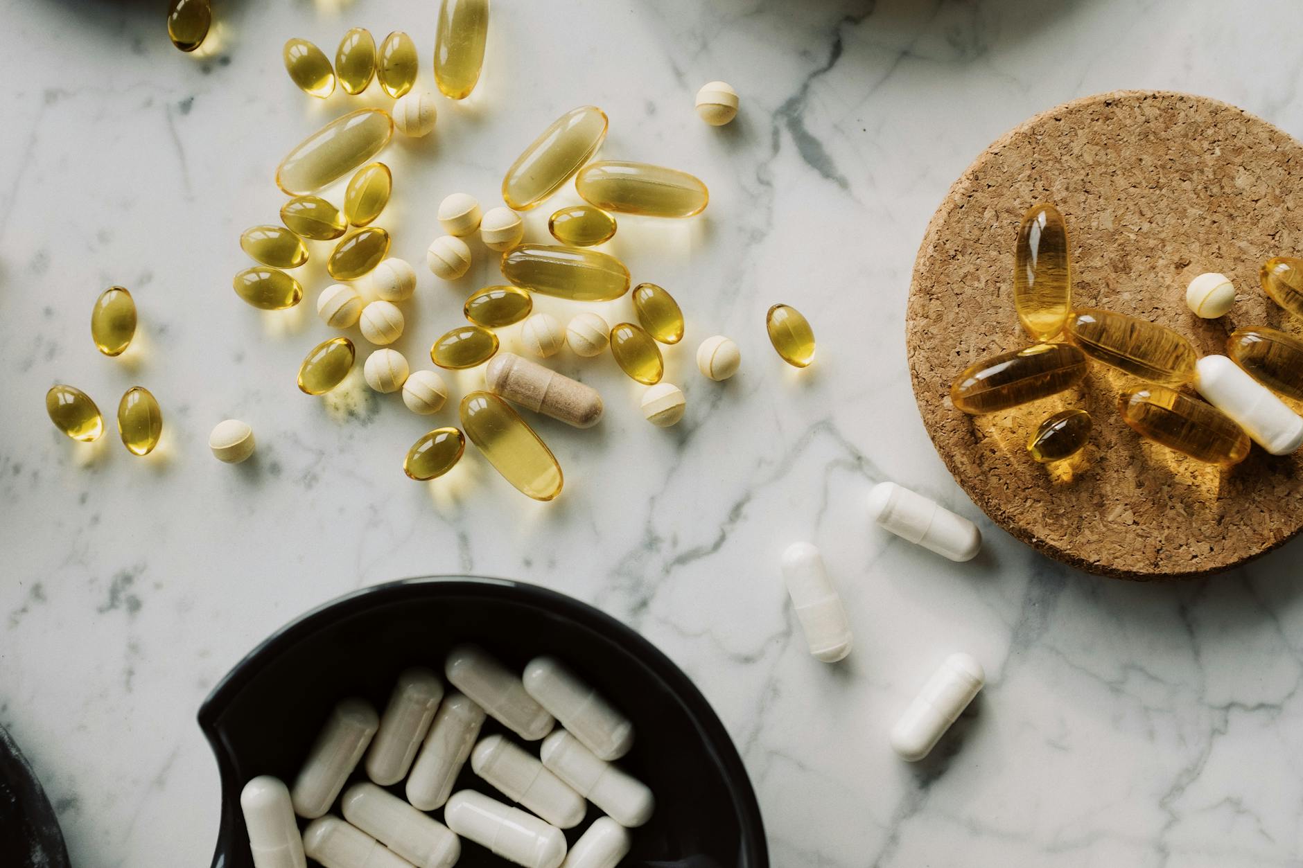 a marble benchtop with tablets, capsules and liquid capsules.